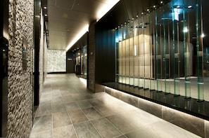 Experience the sleek design of our hotel's corridors, featuring polished tile floors and glass partitions.