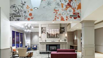 Relax in our elegant lobby, featuring a spacious seating area, fireplace, and beautiful floral mural.