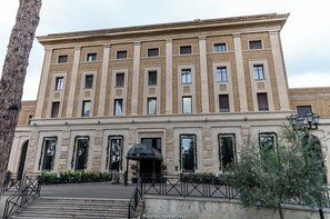 Stately building with a symmetrical facade, featuring evenly spaced windows and a central entrance.