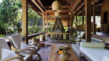 Relax in a serene outdoor space surrounded by lush greenery and comfortable seating.