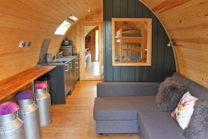 Cozy cabin-style interior with a bench and compact kitchenette for a self-contained stay.